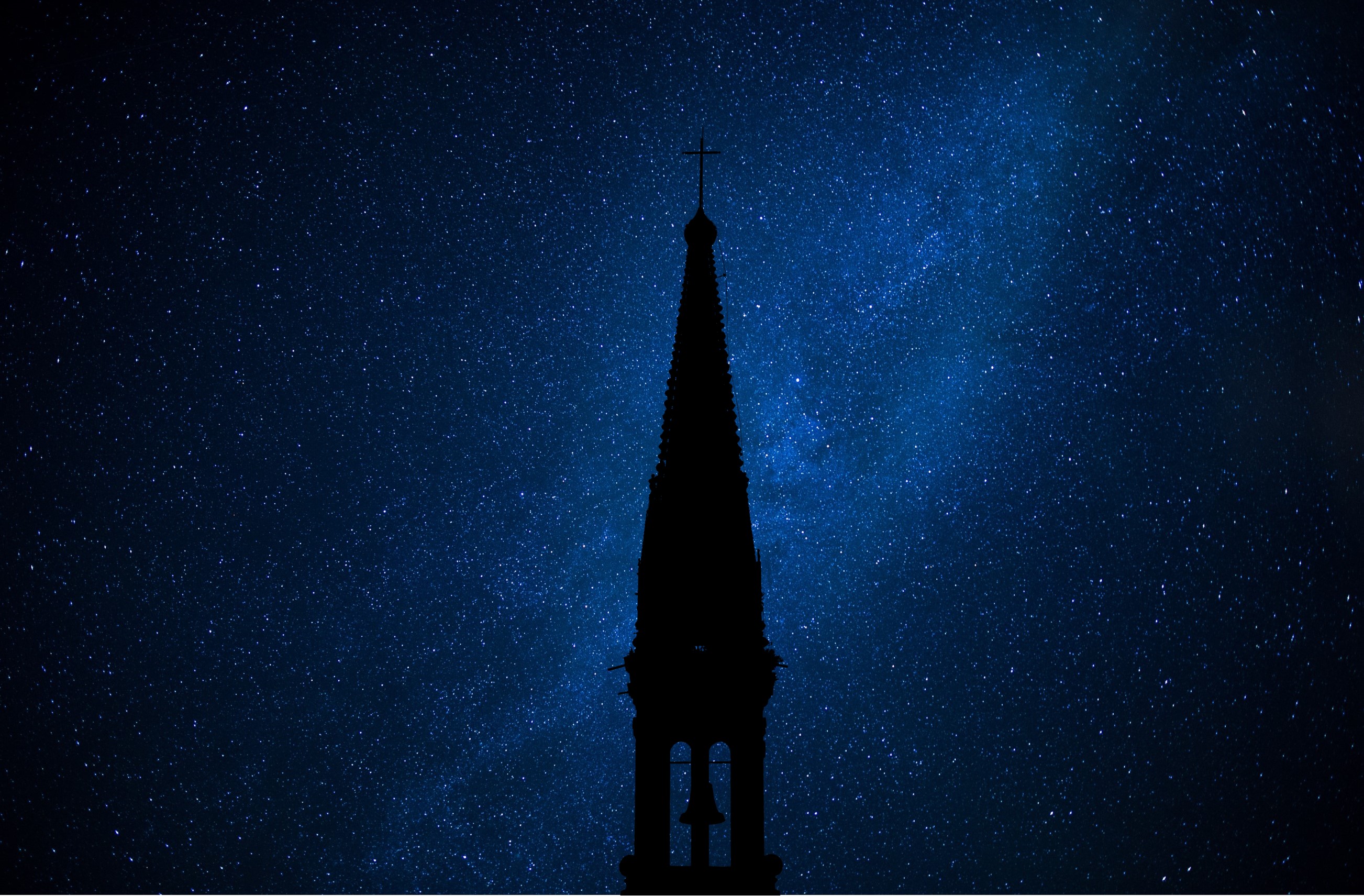 night sky blueish, silhouette of church steeple with cross