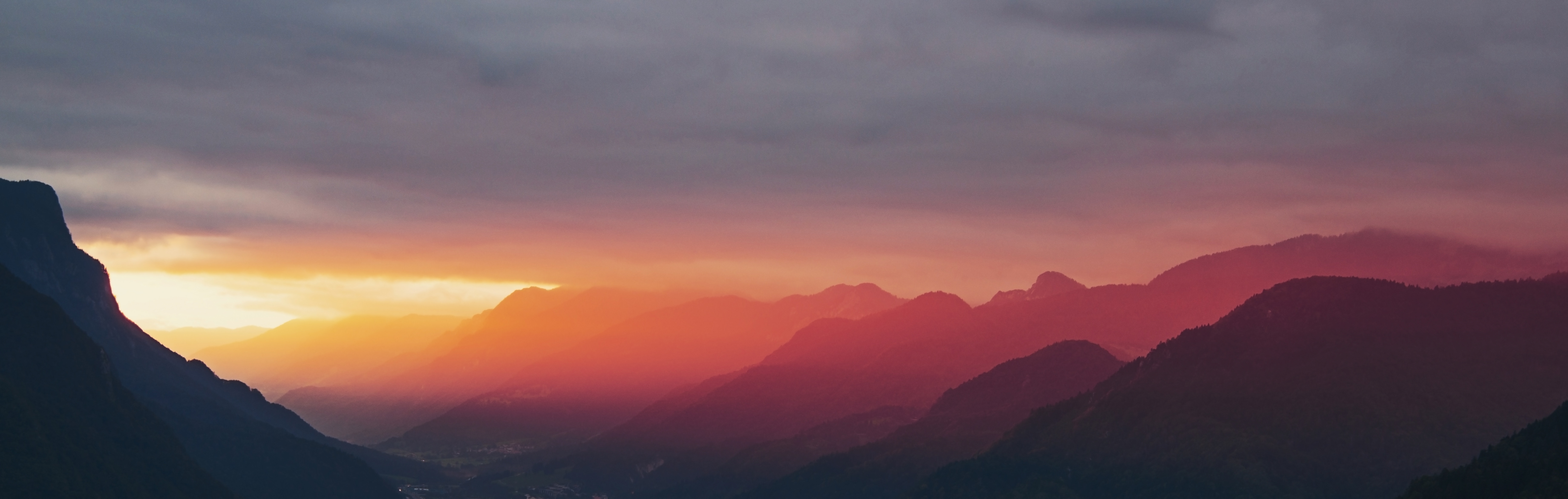 sunrise beside a mountain ridge red hues
